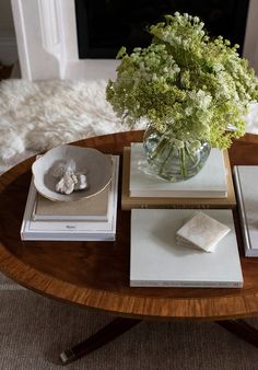 a table topped with books and a vase filled with flowers on top of each other