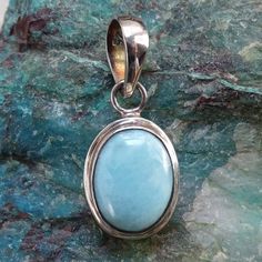 This is a Vintage Blue Larimar Oval Bezel Necklace Pendant Signed 925 Sterling Silver Caribbean Natural Gemstone Larimar Drop Pendant Great Color . The pendant is hallmarked 925 to the inside of the pendant bail. The blue Larimar gemstone is plain bezel set with a large 10mm bail to accommodate a necklace chain. The pendant measures 1 1/8 inch long including the bail, and 1/2 inch wide.  Larimar is a rare blue stone only found in the Dominican Republic. Geographically, it is the Dominican Republic's exclusive gem in the Caribbean, which apparently is the reason for its rarity and value apart from the beauty it possesses. It is said that this gemstome has calming qualities for the wearer. Excellent pre-owned condition. 2257720 Blue Turquoise Cabochon Necklace With Oval Pendant, Luxury Oval Larimar Jewelry, Larimar Gemstone Pendant Necklaces, Oval Blue Larimar Jewelry, Larimar Gemstone Pendant Necklace, Pendant Bail, Bezel Necklace, Pendant Bails, Paua Shell