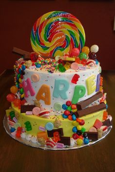 a multi layer cake decorated with candies, lollipops, and candy