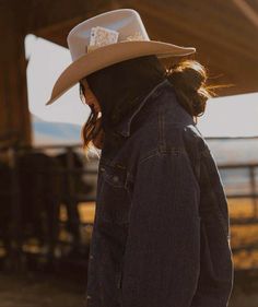 a woman wearing a cowboy hat and jacket