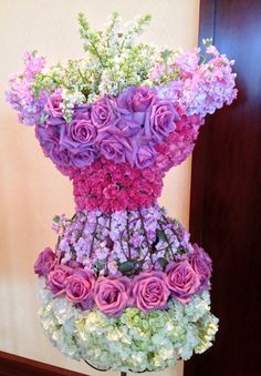 a tall vase filled with lots of purple and white flowers