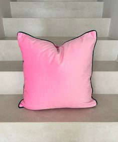 a pink pillow sitting on top of some stairs