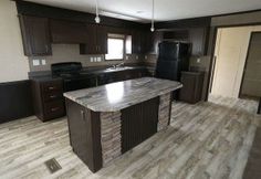 an empty kitchen with granite counter tops and black appliances