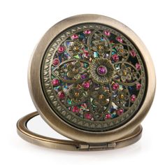 an antique looking pocket watch with colorful jewels