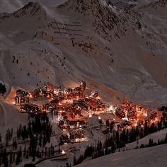 a ski resort lit up at night in the mountains