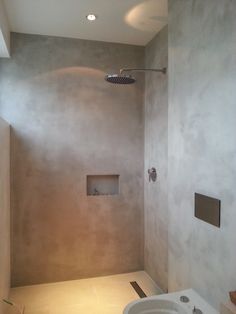 a white sink sitting under a faucet in a bathroom next to a shower