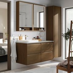 a bathroom with a sink, mirror and wooden cabinetry in it's center