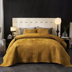 a bed with a yellow comforter and pillows