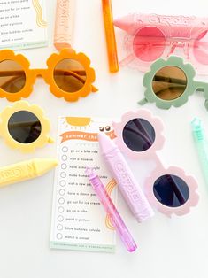 some sunglasses and pens on a table