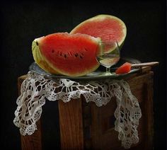 two slices of watermelon on a plate with crochet lace and scissors