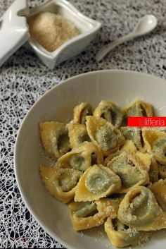 a white bowl filled with dumplings on top of a table