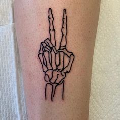 a tattoo on the leg of a person with a hand holding two fingers in it