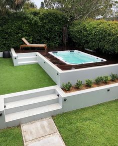 an outdoor hot tub in the middle of a lawn with steps leading up to it