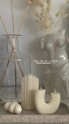 there are candles and vases on the shelf