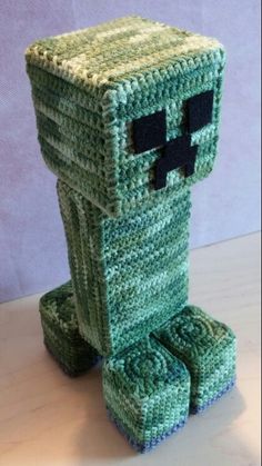 a crocheted creeper toy sitting on top of a table