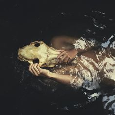 a person is in the water with a fake animal head on their chest and body