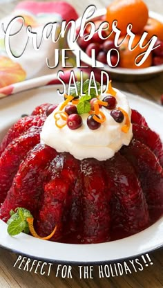 cranberry jello salad on a plate with whipped cream and fruit in the background