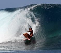 a woman riding a wave on top of a surfboard