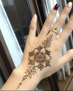 a woman's hand with a flower tattoo on it