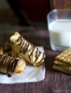 there is a glass of milk next to some crackers and other food on the table