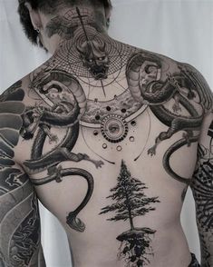 the back of a man's body with tattoos on his chest and two snakes