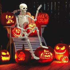 a skeleton sitting on a bench surrounded by carved pumpkins