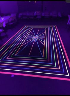 an illuminated dance floor in a dark room with chairs around it and neon lights on the floor