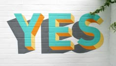 the word yes painted on a white brick wall