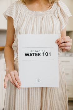 a woman holding up a sign that says water 101