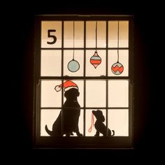 a dog sitting in front of a window with ornaments on it