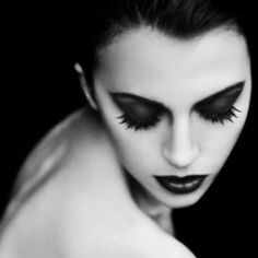 a woman with black makeup and long eyelashes