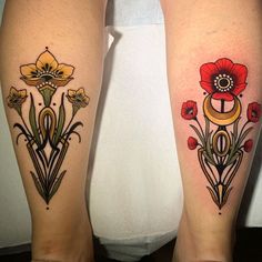 two tattoos on both legs with flowers and an anchor in the middle one is red