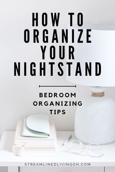 a white lamp sitting on top of a table next to a book and papers with the words how to organize your nightstand