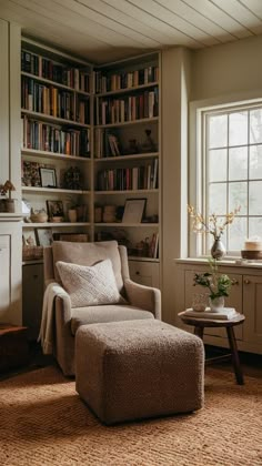 a chair and ottoman in front of a bookshelf with many books on it