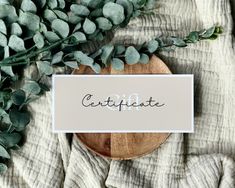 a wooden plate with a sign that says congratulations on it next to some green plants