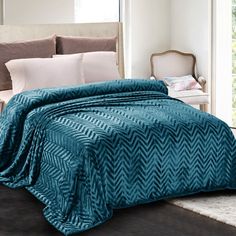 a bed with a blue blanket on top of it