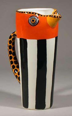 a black and white striped cup with an orange handle