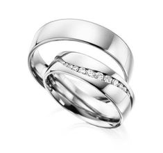 two white gold wedding rings with diamonds on each side and one diamond in the middle