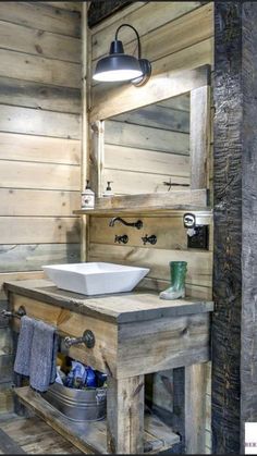 a bathroom with wooden walls and a sink in the center, surrounded by wood planks