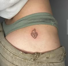 a woman's stomach with a small tattoo on her lower back and an owl in the center