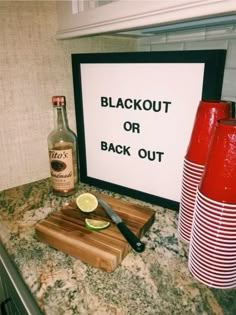 there is a sign that says blackout or back out on the counter next to two red vases