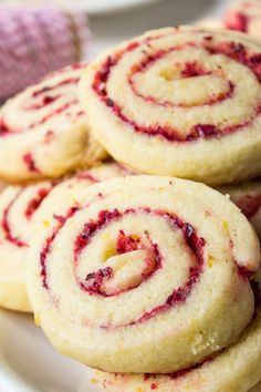 some very tasty looking cookies on a plate with raspberry swirls in the middle