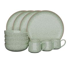 a set of green dinnerware on a white background