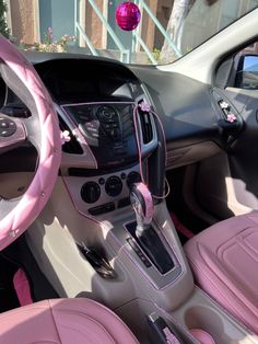 the interior of a pink and black car