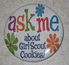 a button with the words ask me about girls scout cookies on it's side