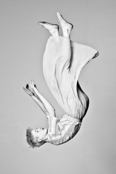 a woman is flying through the air with her legs spread out in front of her