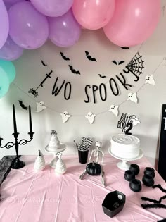 a table topped with lots of balloons next to a sign that says two spooks