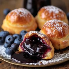 blueberry danish pastries on a plate with powdered sugar and berries next to them