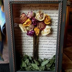 a shadow box with some flowers in it