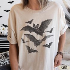 Vintage Bat Halloween Shirt | Goblincore Shirt | Grungy Gothic Graphic Tee  Bat Sweatshirt -> https://bit.ly/44hhWeA   This is a unisex shirt - if you would like an oversized tee, size up one or two sizes to get the desired look. If you want a tighter fit, go for a size down - have a look at the size guide in the listing to compare sizes.  T-shirt Details   *PLEASE READ*  * 100% Cotton (Fiber content may vary for different colors) * Gildan Unisex Short Sleeve Heavy Cotton Tee  * Classic Fit  * P Witchy Graphic Tees, Fall Goblincore Crew Neck T-shirt, Halloween Goblincore T-shirt With Graphic Print, Halloween Fairy Grunge T-shirt With Crew Neck, Halloween Goblincore Graphic T-shirt, Fairy Grunge Halloween T-shirt With Crew Neck, Black Goblincore Tops For Halloween, Halloween Goblincore Crew Neck Top, Halloween Long Sleeve Fairy Grunge Tops